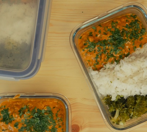 Creamy spiced chicken with jasmine rice and broccoli in glass meal-prep boxes