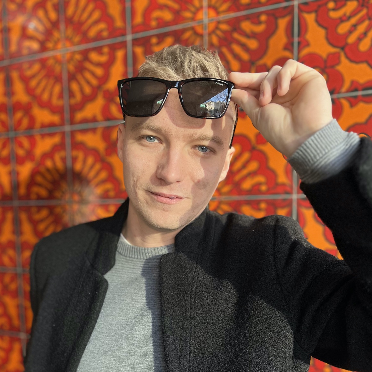 Adrian, creator of GRYZO, in front of an orange mural